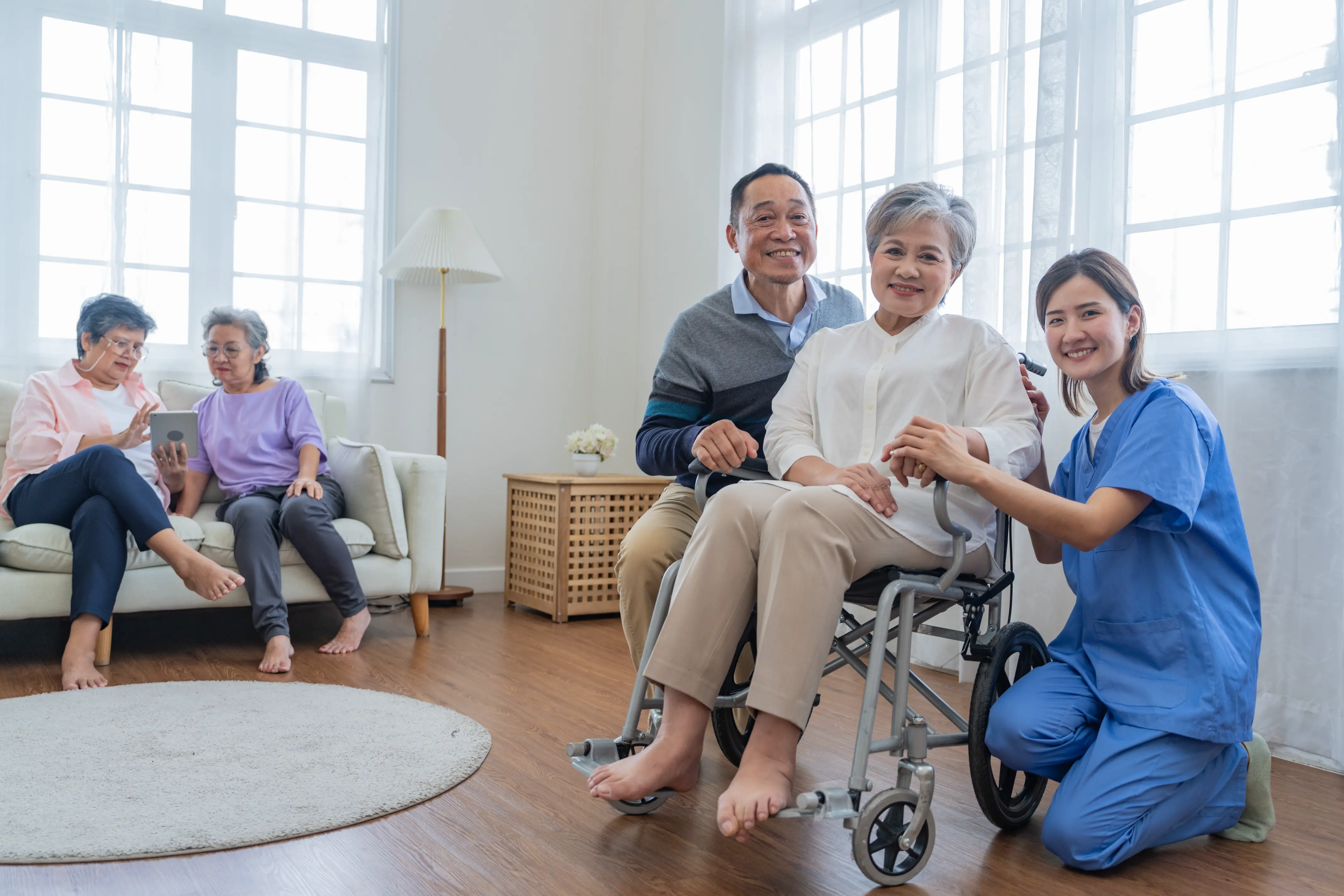High Support Care worker pushing a client in a wheelchair through a living room